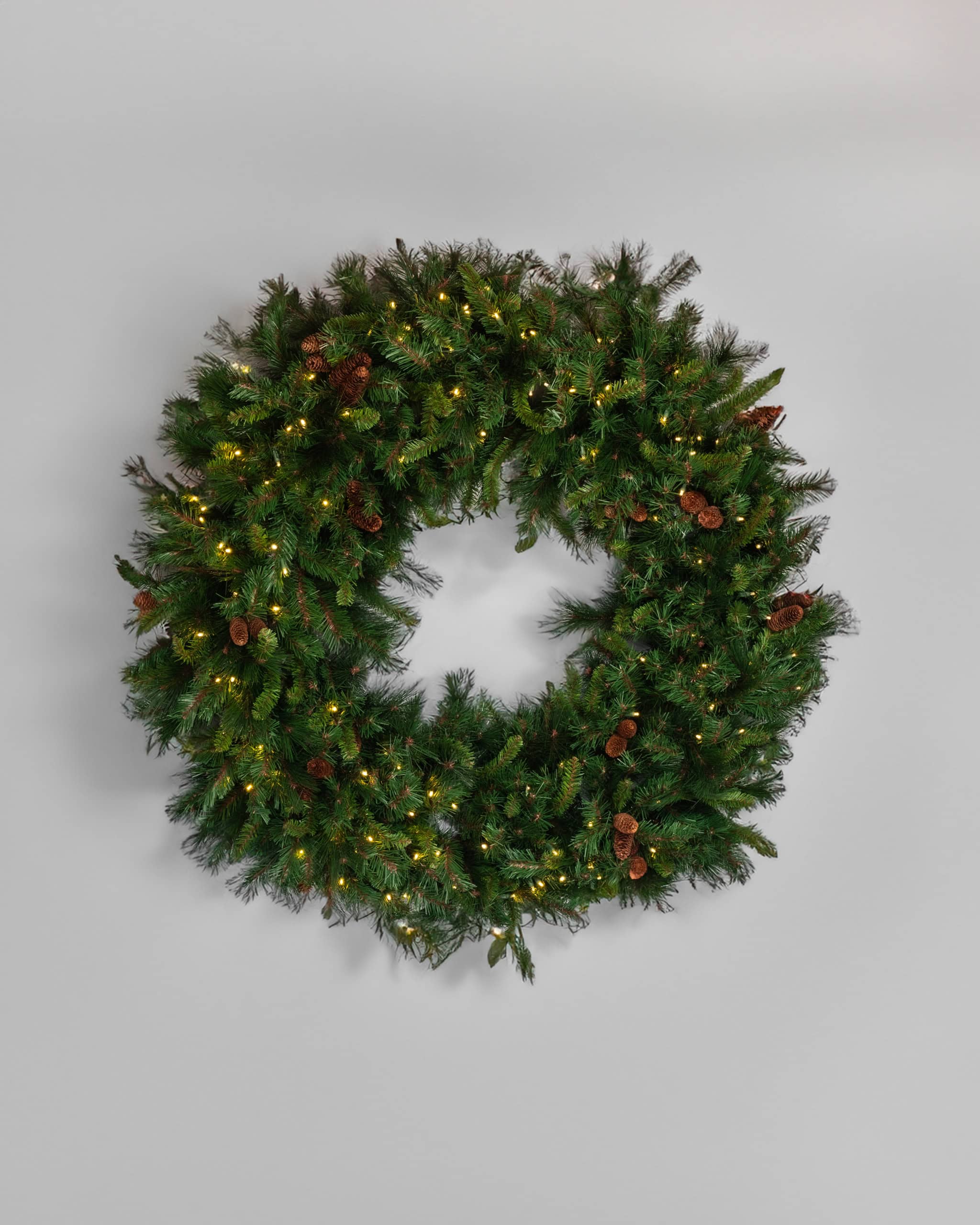 1. Festive Christmas wreath with lights and pinecones for holiday decoration.