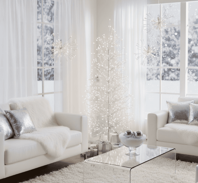 White illuminated Christmas tree with LED lights in a modern living room.